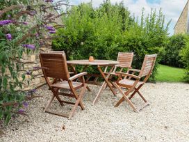 A table and three chairs in a garden at Peewit Barn in Moreton-in-Marsh