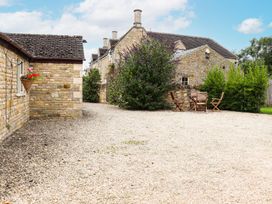 An outdoor area with gravel and wooden furniture at Peewit Barn Moreton-in-Marsh