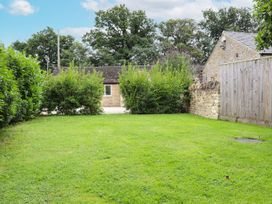 A garden area with grass and hedges at Peewit Barn in Moreton-in-Marsh