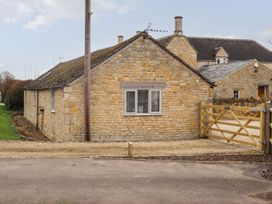 A stone building with a window and gate at Peewit Barn in Moreton-in-Marsh