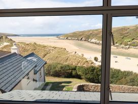 A view of a beach and ocean from a window at Chy-an-Lowena in Crantock