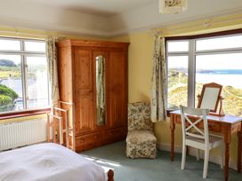 A bedroom with a wardrobe and desk at Chy-an-Lowena Crantock