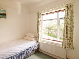 A bedroom with a bed and a window at Chy-an-Lowena in Crantock