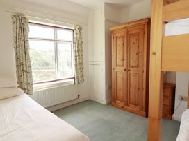 A bedroom with a bed and wardrobe at Chy-an-Lowena in Crantock