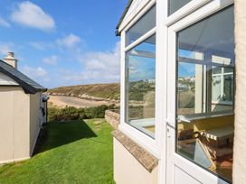 A view of the garden with a house and sea at Chy-an-Lowena in Crantock