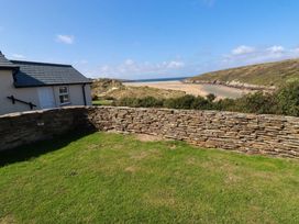 A view of a beach from a stone wall at Chy-an-Lowena in Crantock
