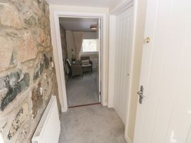 A hallway with a stone wall and access to a room at Hafan y Tyddyn 