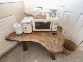 A wooden table with appliances and towels in a kitchen at Hafan y Tyddyn
