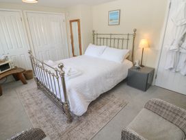 A bedroom with a bed and nightstand at Hafan y Tyddyn