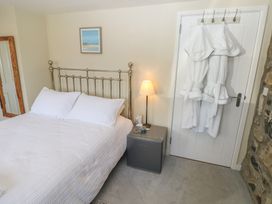 A bedroom with a bed and bedside table at Hafan y Tyddyn