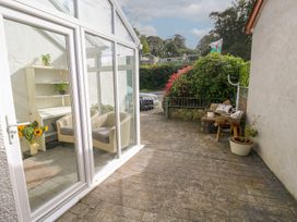 A conservatory with chairs and shelves at Hafan y Tyddyn