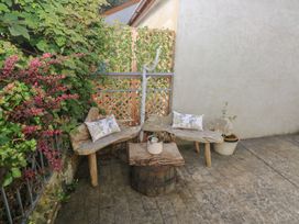 An outdoor seating area with wooden benches and a table at Hafan y Tyddyn