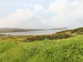 A view of a beach with grass and hills at Hafan y Tyddyn in 