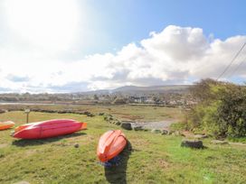 A view of kayaks on grass with hills and houses in the background at Hafan y Tyddyn 