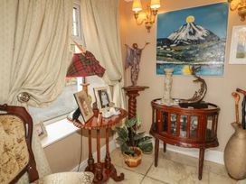 An entryway with a lamp and table displaying pictures at Bruckless Rest Fine Country Dining B&B Bruckless