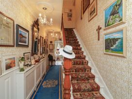 A hallway with a staircase and wall art at Bruckless Rest Fine Country Dining B&B Bruckless