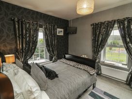 A bedroom with a bed and windows at Bruckless Rest Fine Country Dining B&B in Bruckless