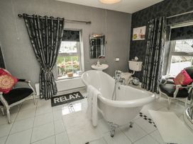 A bathroom with a bathtub and toilet at Bruckless Rest Fine Country Dining B&B in Bruckless