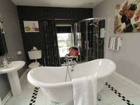 A bathroom with a bathtub and shower at Bruckless Rest Fine Country Dining B&B in Bruckless