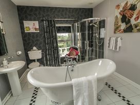 A bathroom with a bathtub and shower enclosure at Bruckless Rest Fine Country Dining B&B, Bruckless