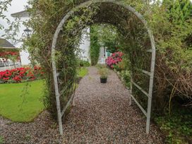 A garden with an archway and gravel path at Bruckless Rest Fine Country Dining B&B, Bruckless