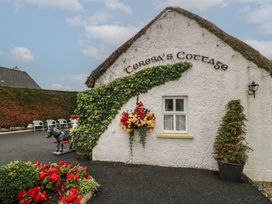 An outdoor view of Teresa's Cottage with flower planters and decorative elements in Bruckless
