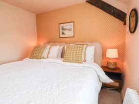 A bedroom with a double bed and wall decor at Myrtle Cottage in Lynmouth