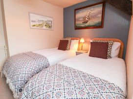 A bedroom with twin beds and a lamp at Myrtle Cottage in Lynmouth