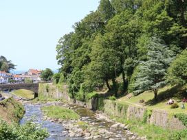 A view of a river with trees and a bridge at Myrtle Cottage in Lynmouth