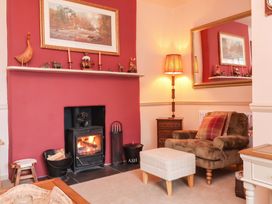 A living room with a fireplace and a settee at Myrtle Cottage in Lynmouth