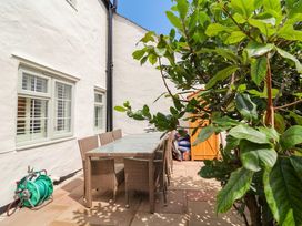 An outdoor patio with a dining table and chairs at Myrtle Cottage in Lynmouth