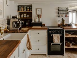A kitchen with a coffee machine and oven at Rose Cottage in Gweek