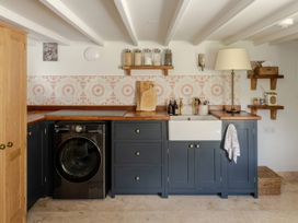 A kitchen with a washing machine and a sink at Rose Cottage in Gweek