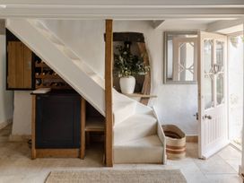 A hallway with stairs and a wine rack at Rose Cottage in Gweek