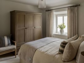 A bedroom with a bed and wardrobe at Rose Cottage in Gweek