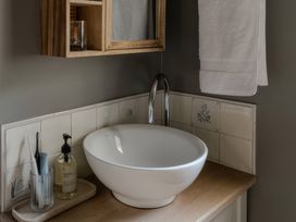 A bathroom with a sink and accessories at Rose Cottage in Gweek