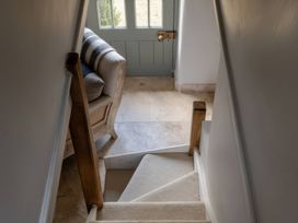 A hallway with a staircase and a door at Rose Cottage in Gweek