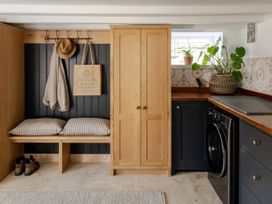 A utility room with a washing machine and storage at Rose Cottage in Gweek