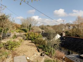 A garden with gravel paths and seating area at Rose Cottage in Gweek