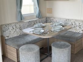 A dining area with a table set for meals at Blue Dolphin Holiday Home in Gristhorpe
