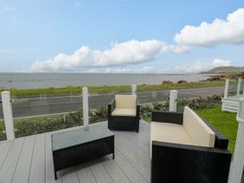 A patio area with seating overlooking the sea at Caravan in Girvan