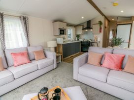 A living room with a coffee table and kitchen area at Caravan in Girvan