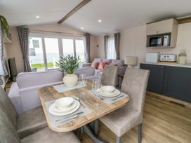 A living room with a sofa and dining table at Caravan in Girvan