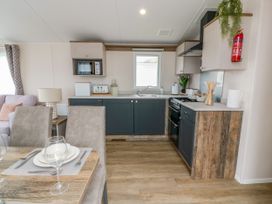 A kitchen with cabinets and appliances at Caravan in Girvan