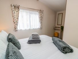 A bedroom with a bed and towels stacked neatly at Caravan in Girvan