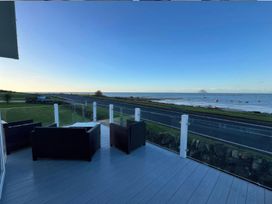 An outdoor area with seating and a view of the ocean at Frontline Sea View : P1 Whilk Meadow in Girvan