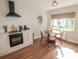 A kitchen with an oven and dining table at Flat 4 in Tenby