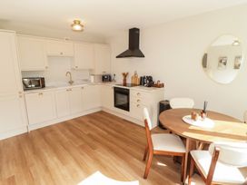 A kitchen with cabinets and dining table at Flat 4 in Tenby