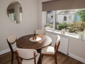 A dining room with a round table and chairs at Flat 4 Tenby