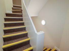 A staircase with carpet and a handrail at Flat 4 in Tenby